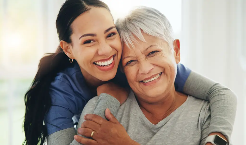 Nurse hugging a smiling patient